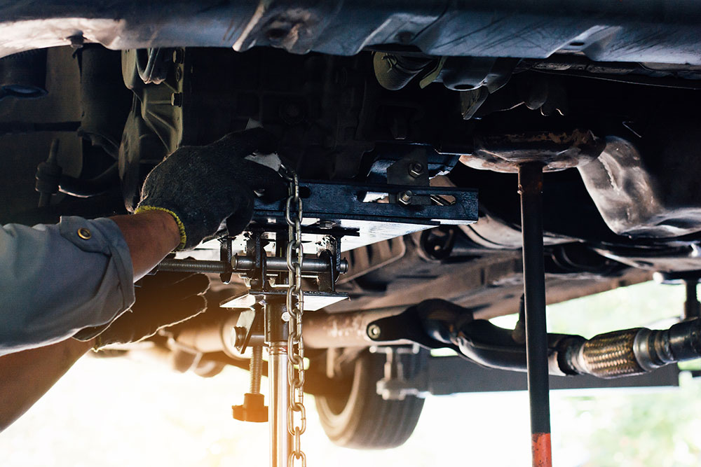 Image of mechanic looking under a car